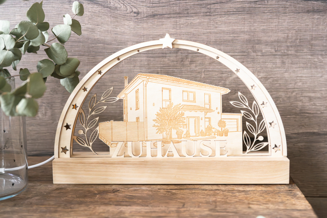 LED-Schwibbogen aus Holz mit gravierter Illustration eines Einfamilienhauses, Olivenzweig-Ranken, Sternen und Schriftzug „Zuhause", warmweißes Licht